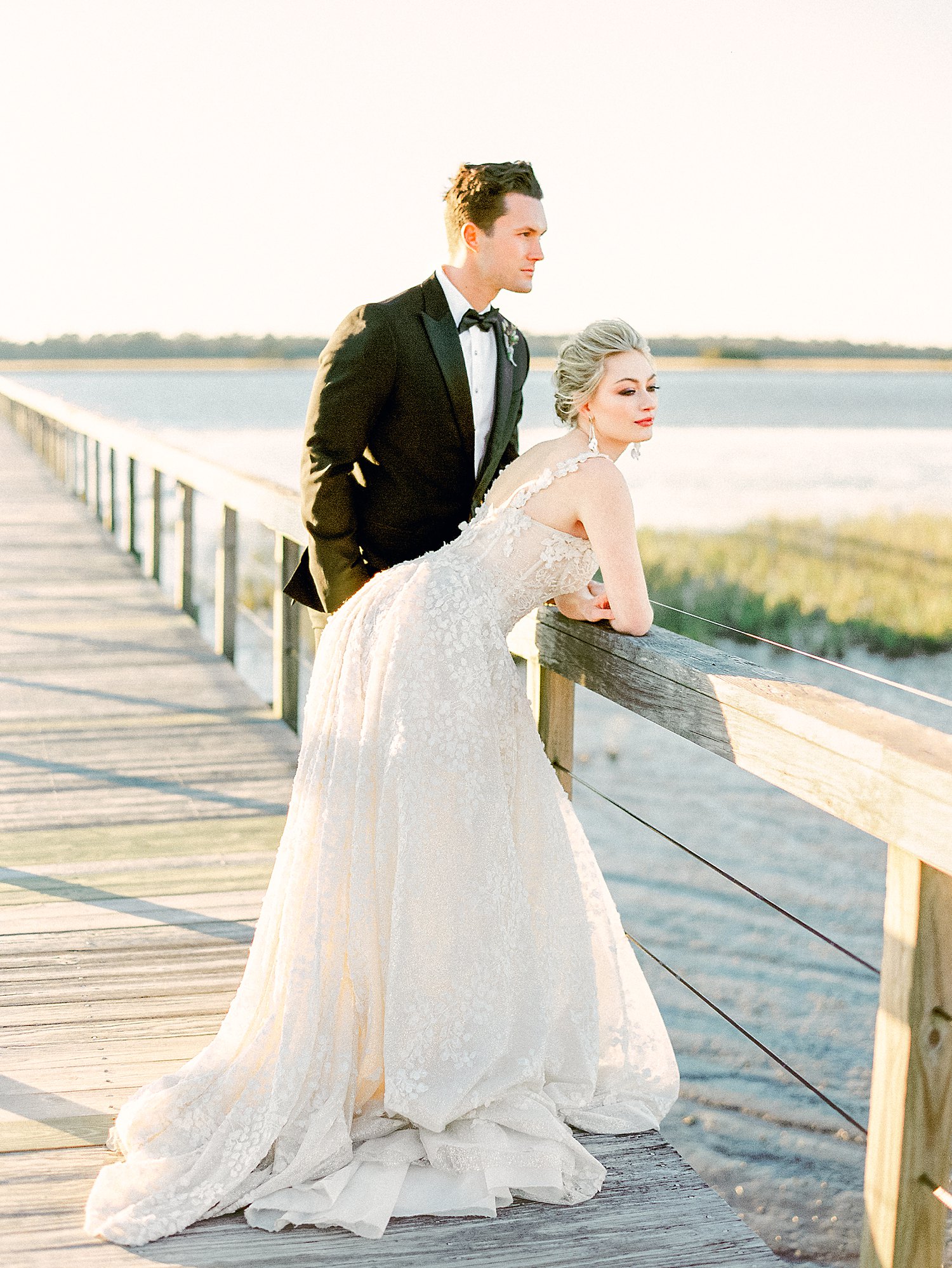Bride and groom standing on wooden dock on river at Charleston Wedding