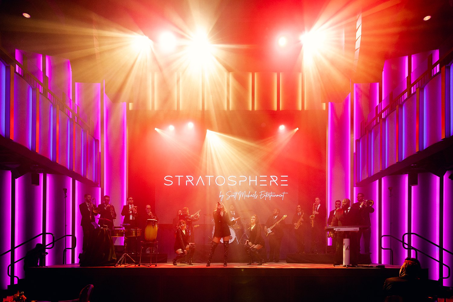 Singers in stratosphere wedding band standing on stage in bright red lights
