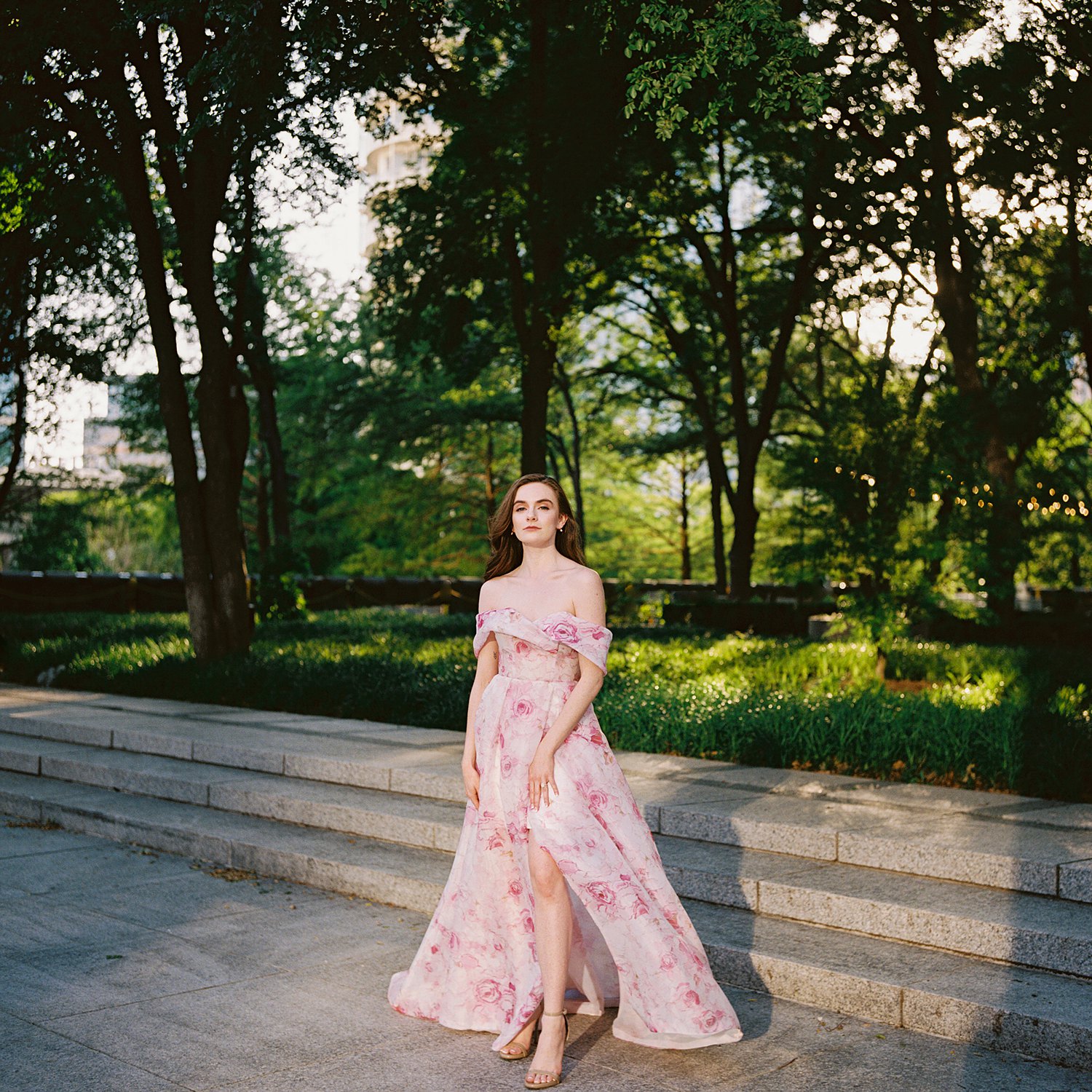 Woman in Pink floral gown in front of garden
