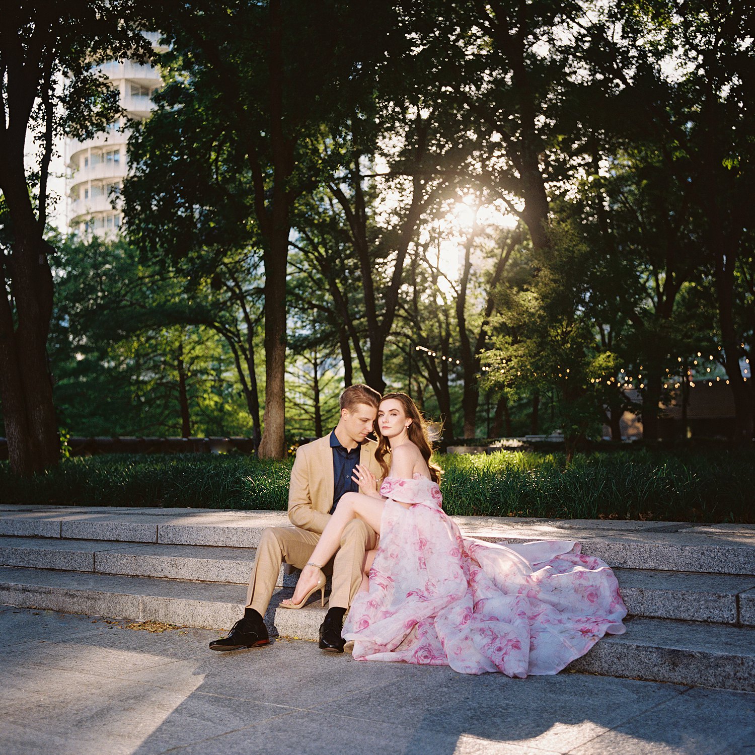 woman in Pink floral gown sitting with man in tan suite and blue shirt dallas engagement