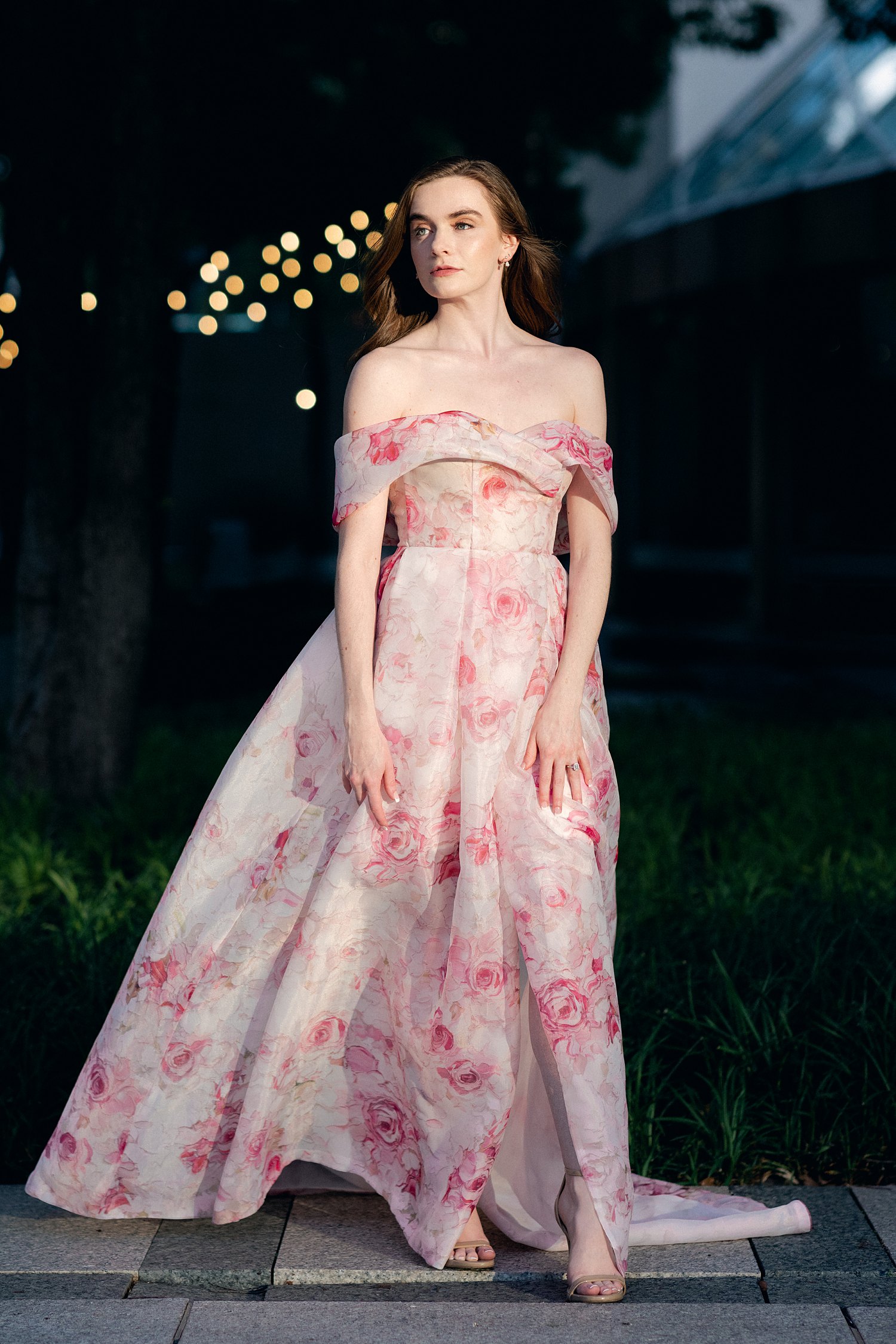 woman in Pink floral gown portrait in front of dark background