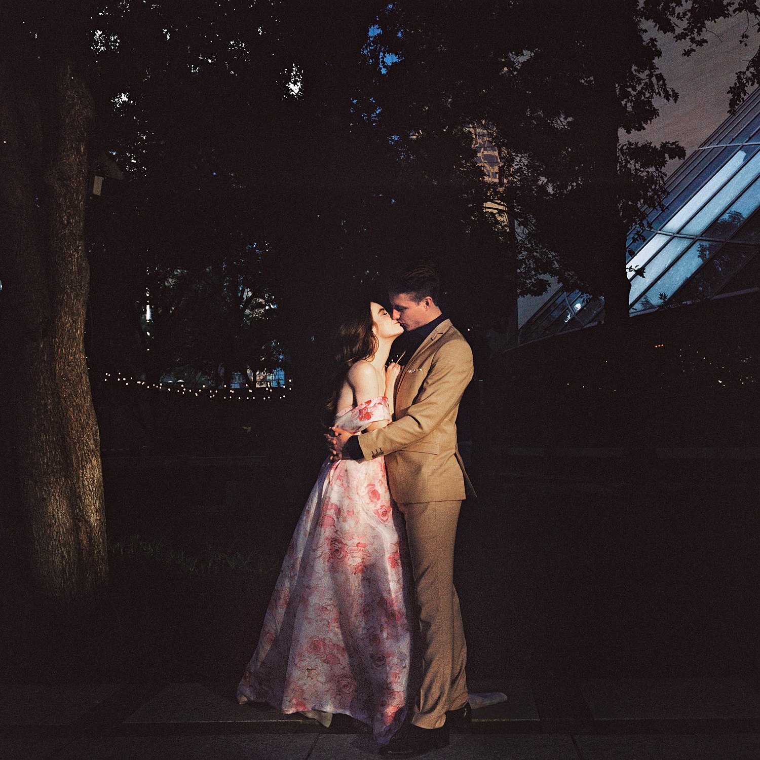 woman in Pink floral gown hugging man in tan suite dallas engagement