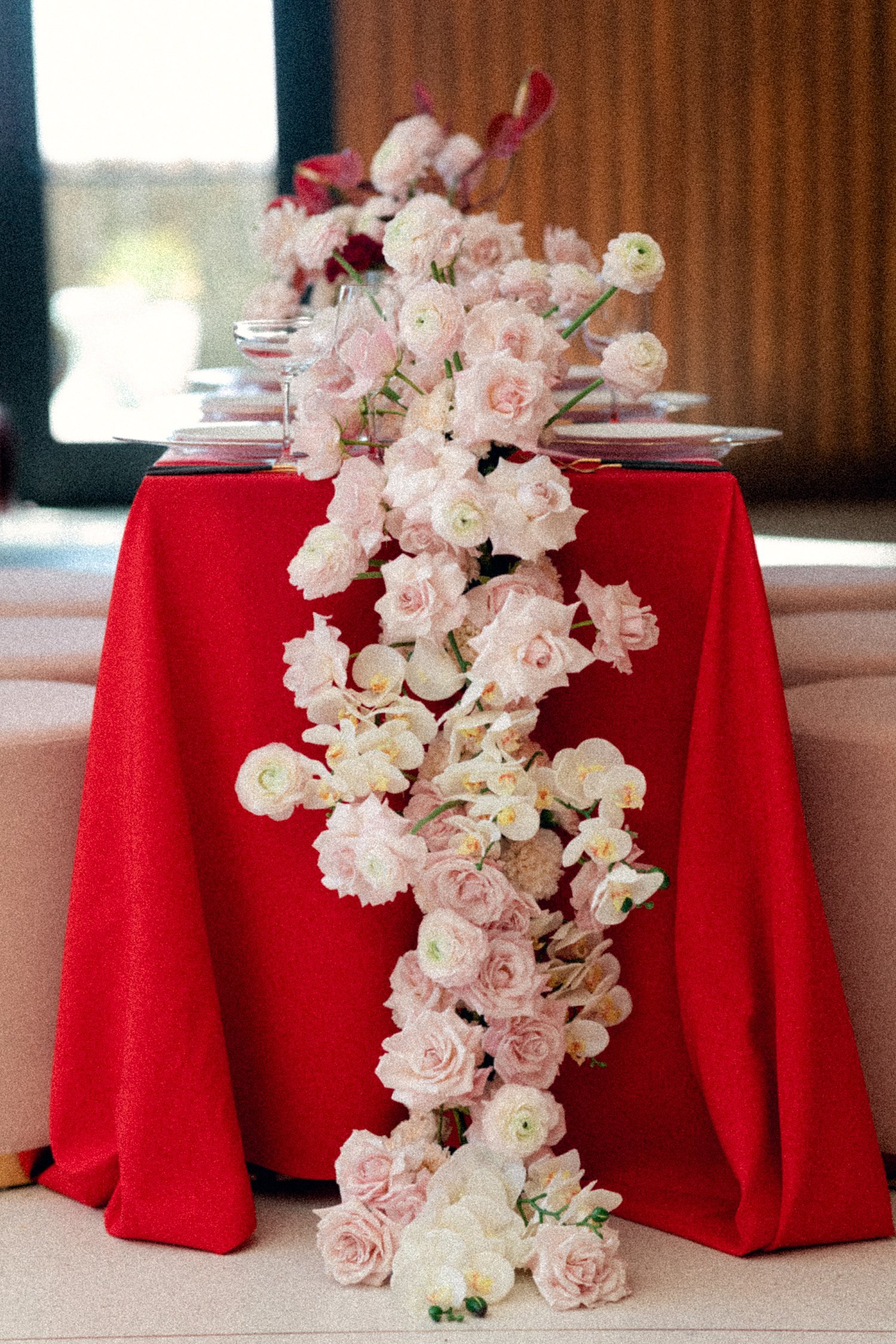 pink and red table floral centerpiece with white stools flower cascade at Virgin Hotel Dallas