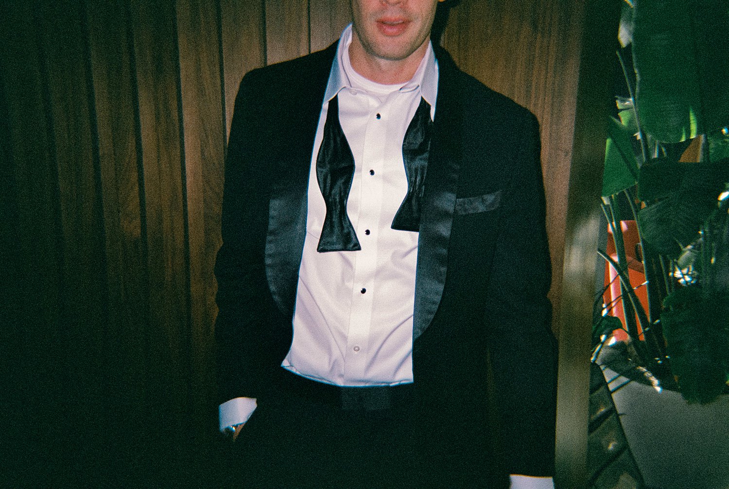Man in black tuxedo and untied bowtie captured on Disposable Camera