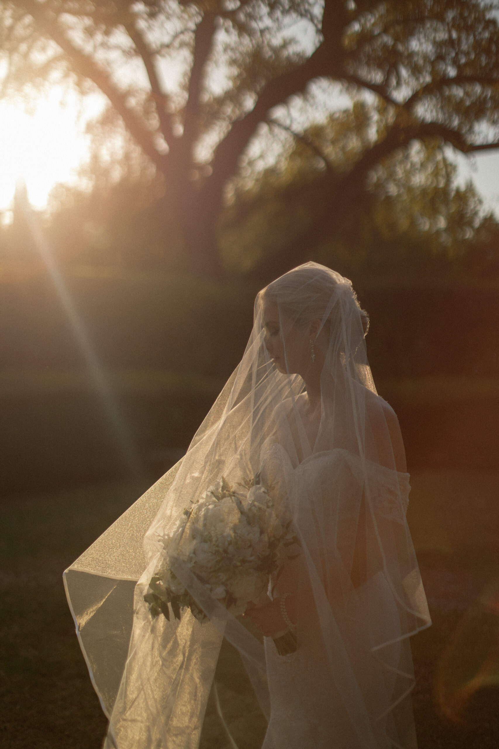 bride holding bouquet at sunset